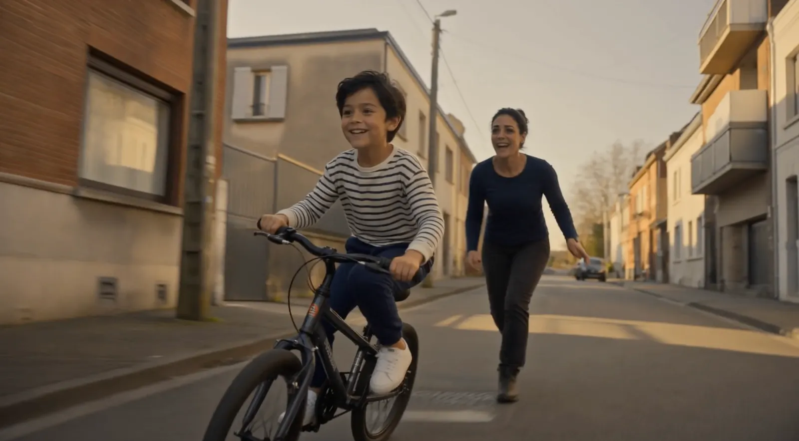 Storyboard frame: the boy rides a bicycle down a sunlit street, his mother running after him