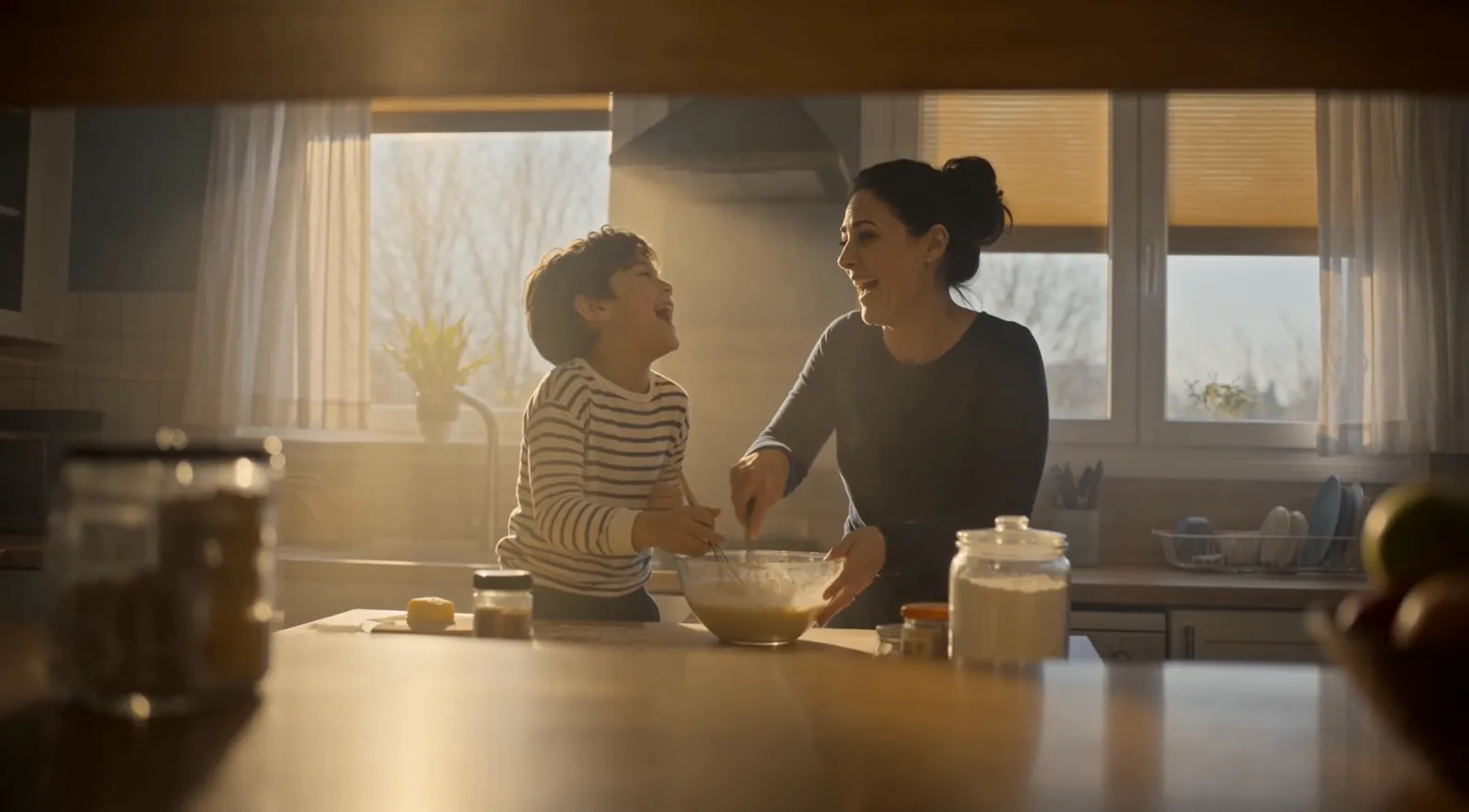 Storyboard frame: mother and son laugh while baking in a warm kitchen
