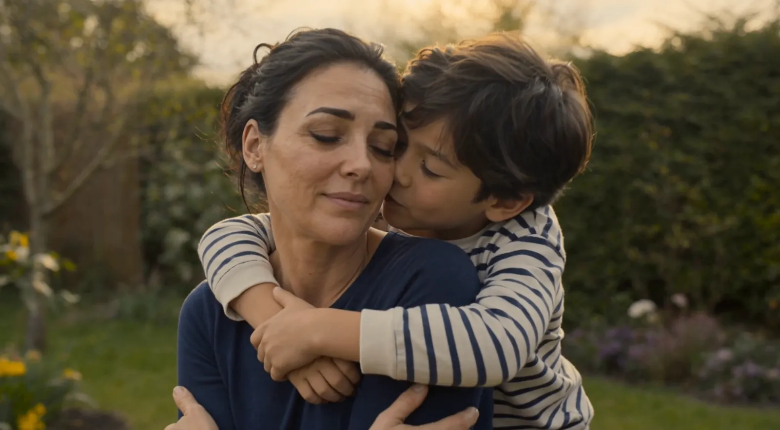 Storyboard frame: the boy hugs his mother from behind in the garden
